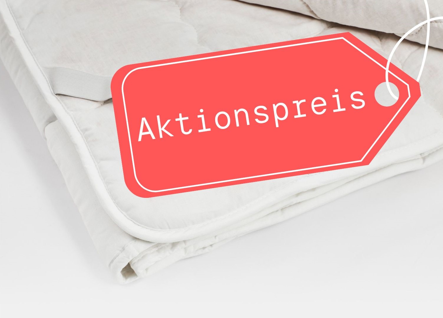 Eine weißes Zirbenunterbett, welches ein rotes Etikett mit der Aufschrift Aktionspreis trägt, auf einem schlichten Untergrund präsentiert